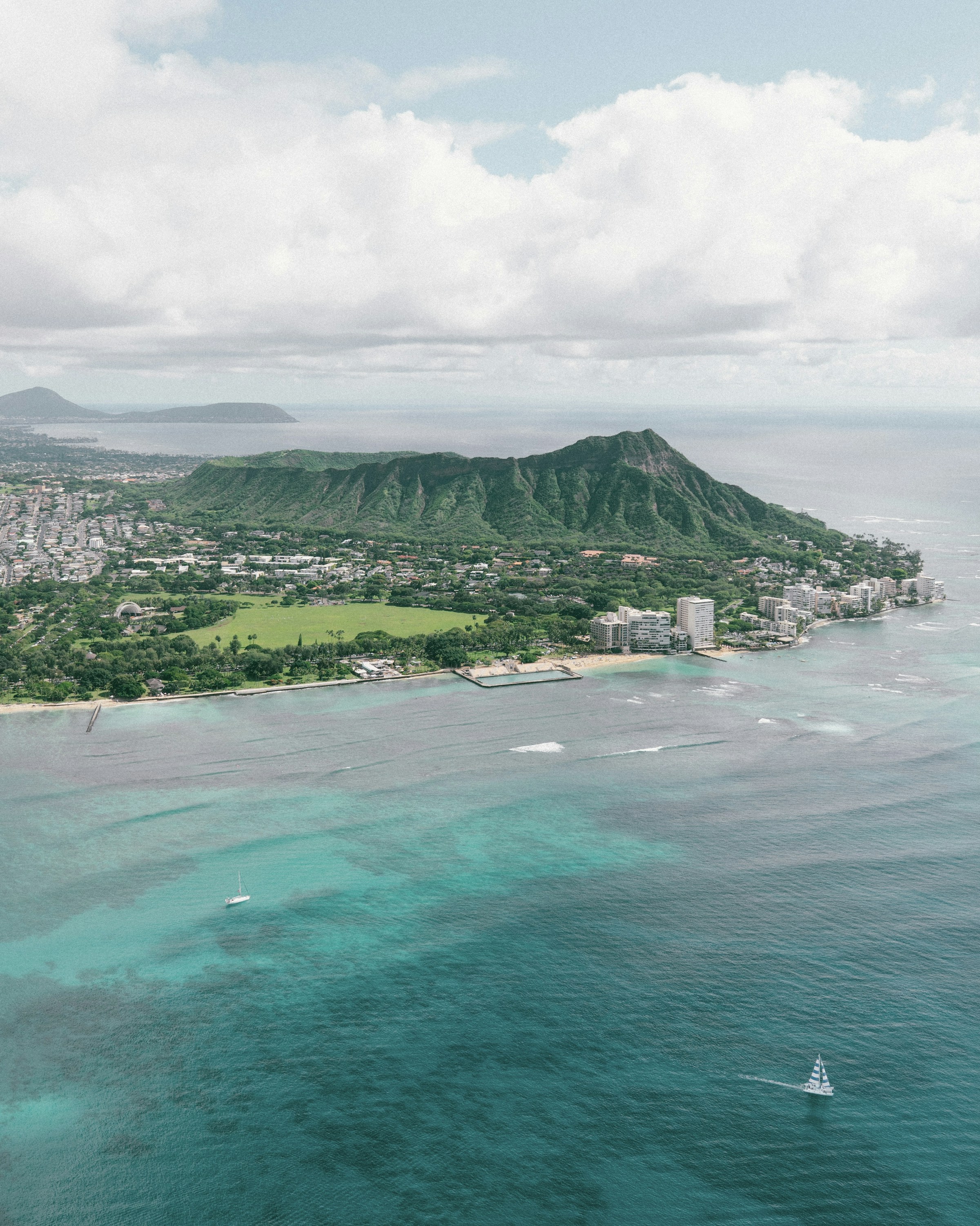 Aerial view of Diamond Head, coastal residences and turquoise ocean on Oʻahu